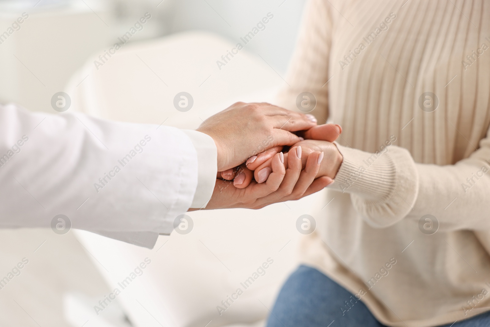 Photo of Doctor supporting patient during appointment in hospital, closeup of hands