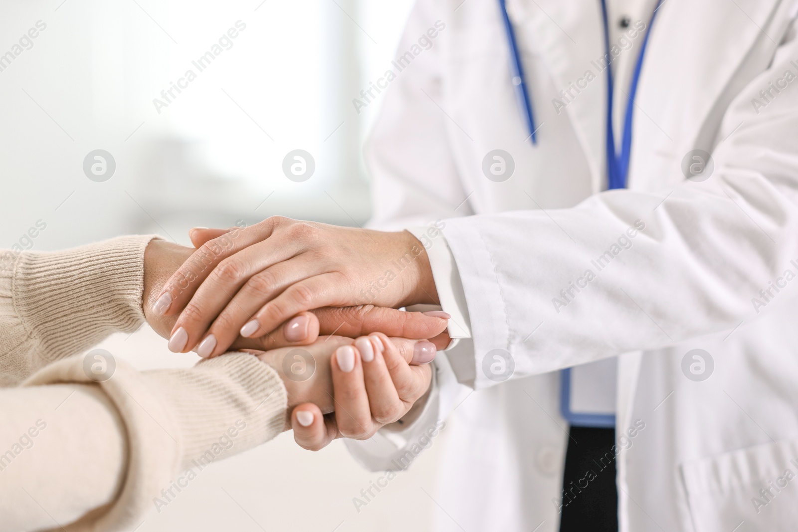 Photo of Doctor supporting patient during appointment in hospital, closeup of hands