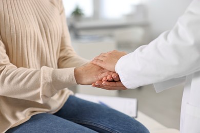 Photo of Doctor supporting patient during appointment in hospital, closeup of hands