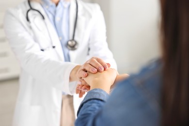 Photo of Doctor supporting patient during appointment in hospital, closeup of hands