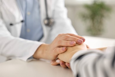 Photo of Doctor supporting patient during appointment in hospital, closeup of hands