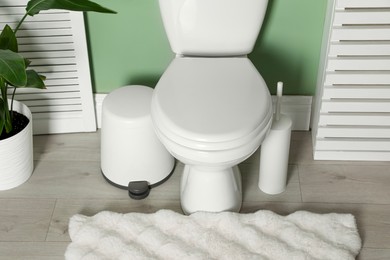 Photo of Ceramic toilet bowl and necessities in restroom