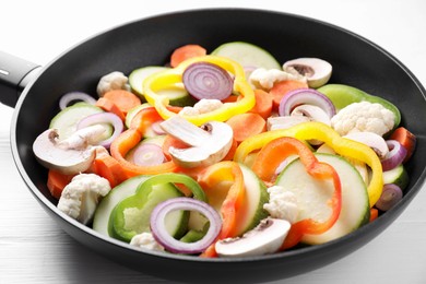 Photo of Frying pan with mix of vegetables and mushrooms on white table, closeup