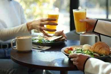 Photo of Women having tasty breakfast in cafe, closeup