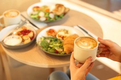 Photo of Woman having tasty breakfast in cafe, closeup