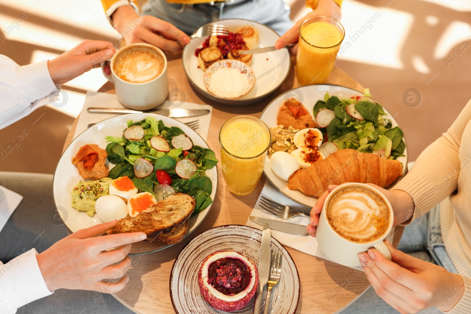 Photo of Women having tasty breakfast in cafe, closeup