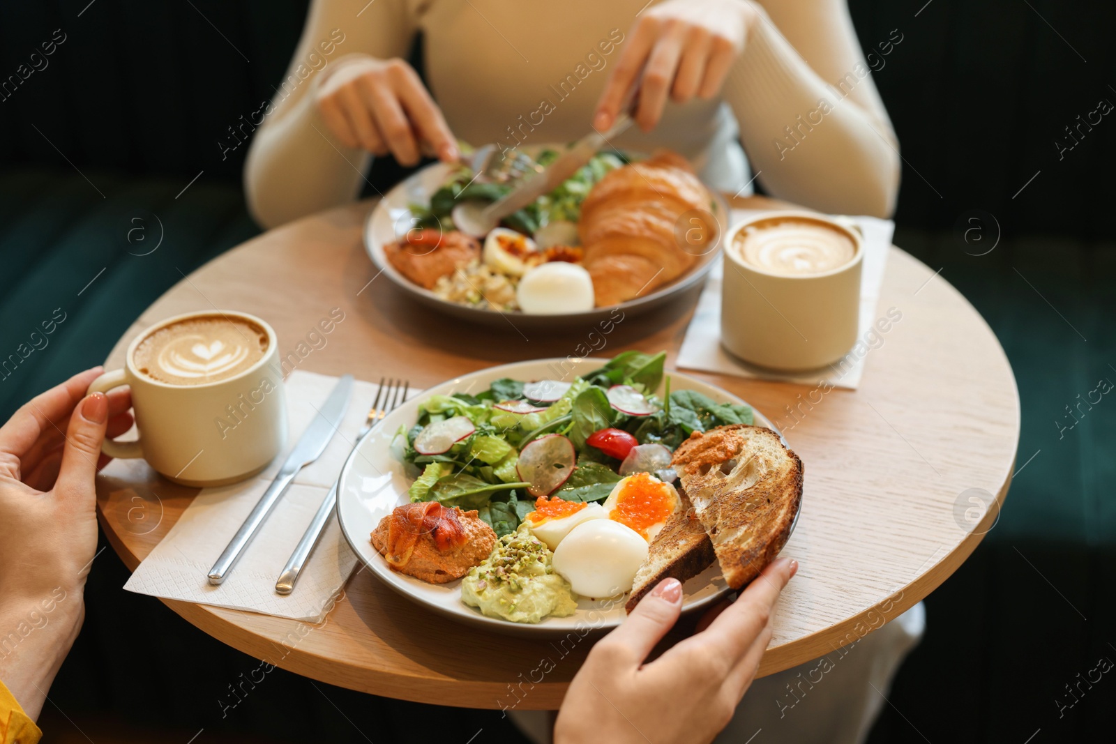 Photo of Women having tasty breakfast in cafe, closeup