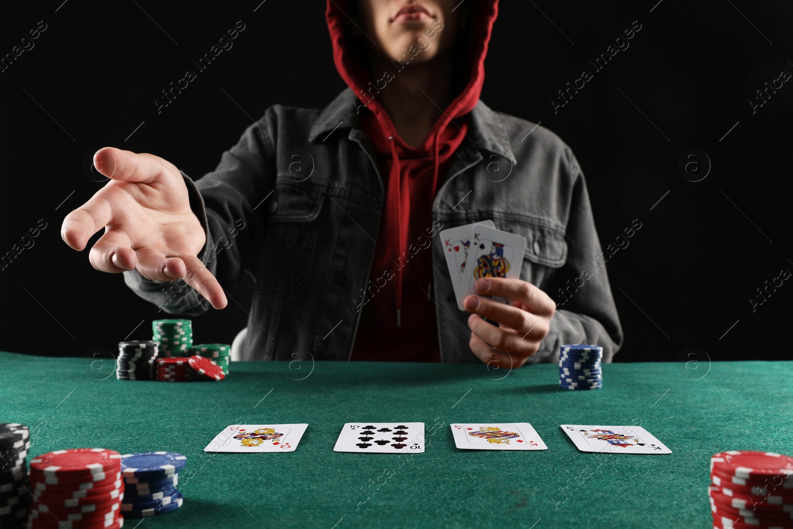 Photo of Man with cards and casino chips playing poker at gambling table, closeup