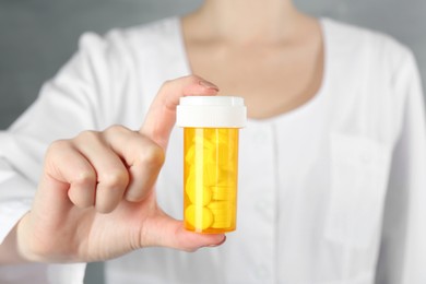 Photo of Doctor holding medical bottle of antibiotic pills, closeup