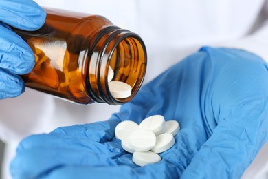 Photo of Doctor with bottle of antibiotic pills, closeup