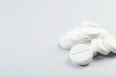 Photo of Pile of antibiotic pills on grey background, closeup. Space for text