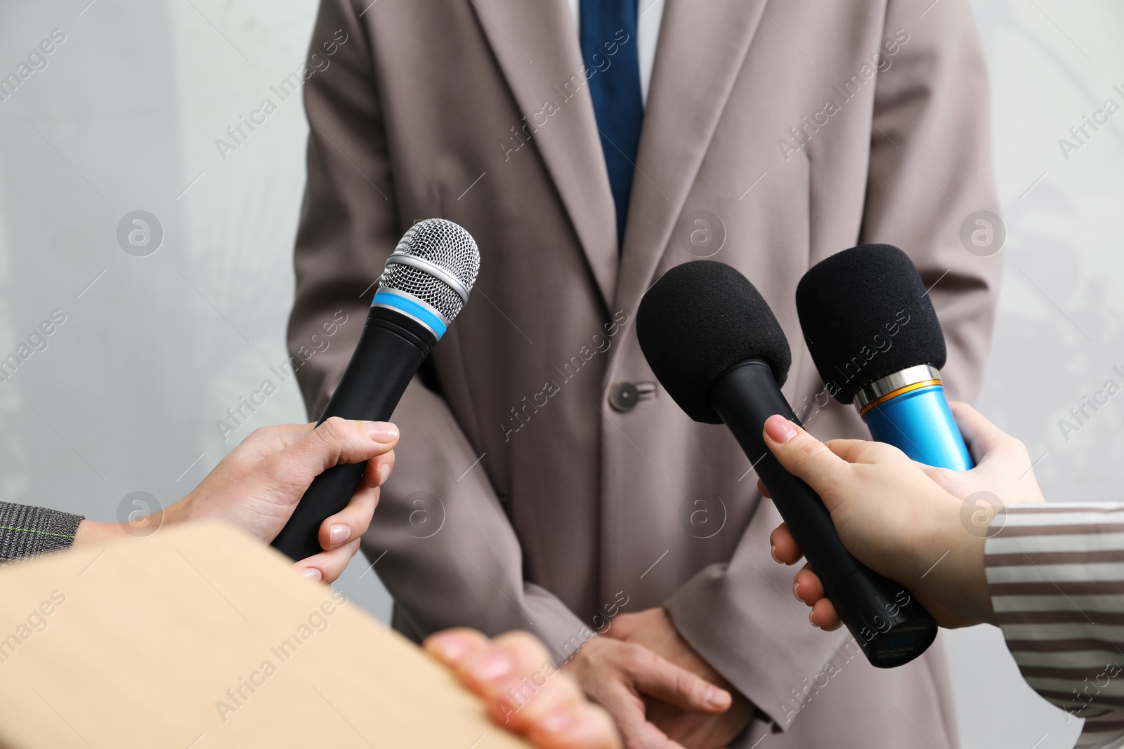 Photo of Group of journalists interviewing businessman indoors, closeup