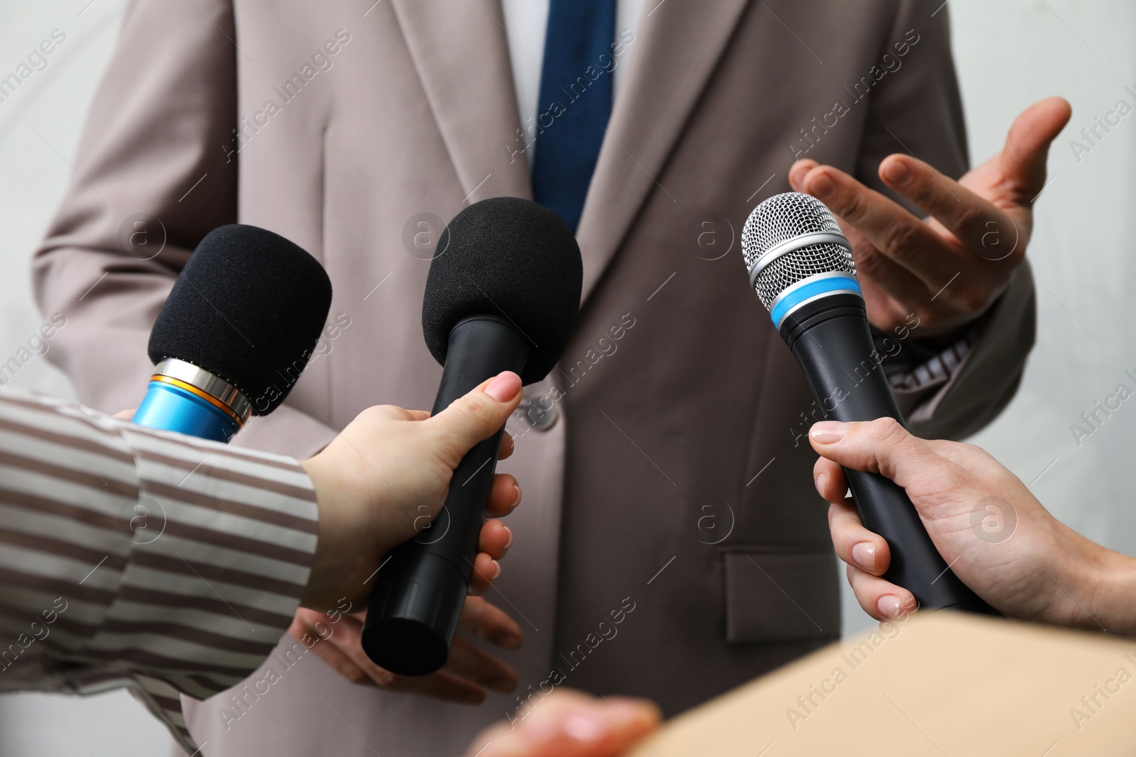 Photo of Group of journalists interviewing businessman indoors, closeup