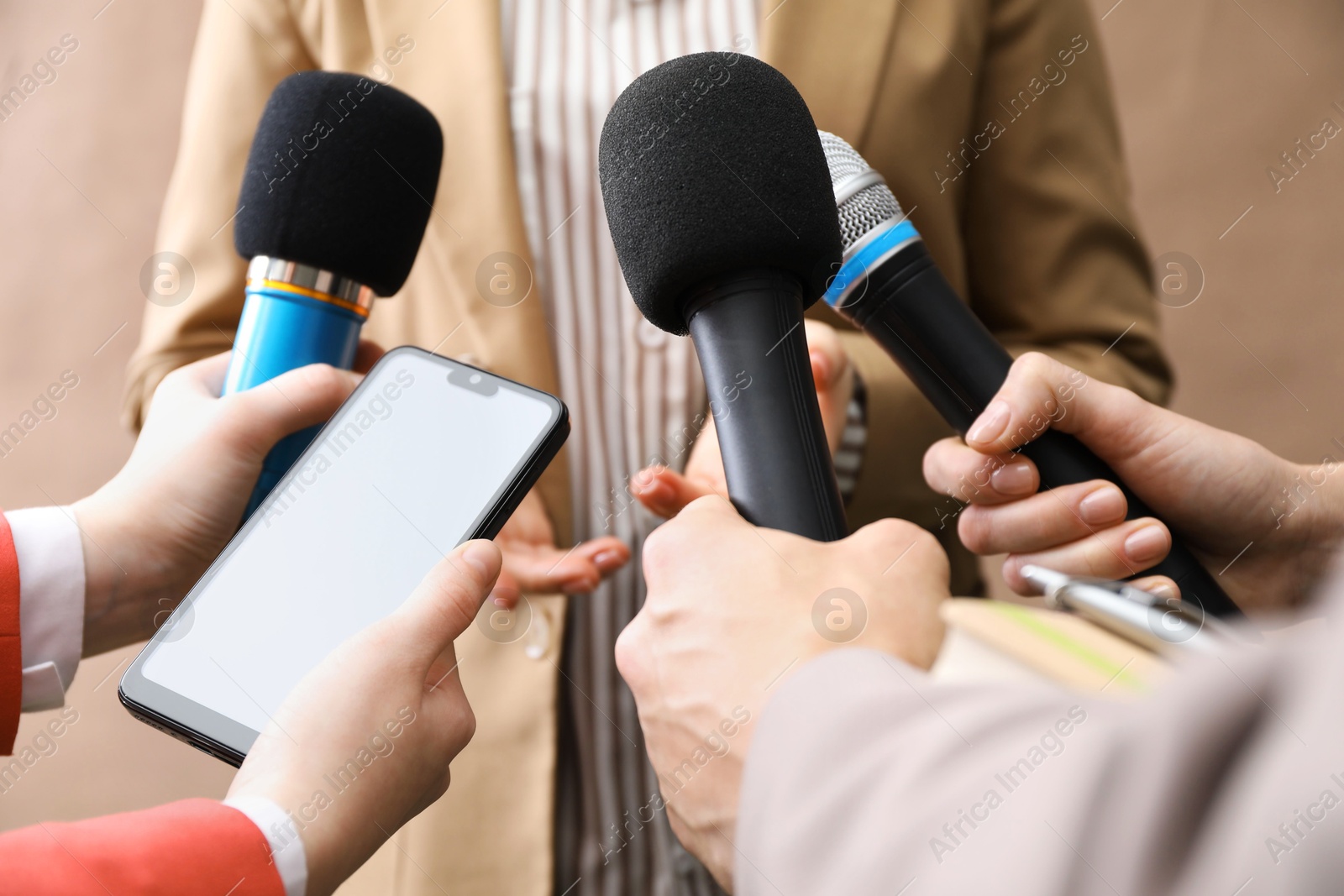 Photo of Group of journalists interviewing businesswoman on beige background, closeup