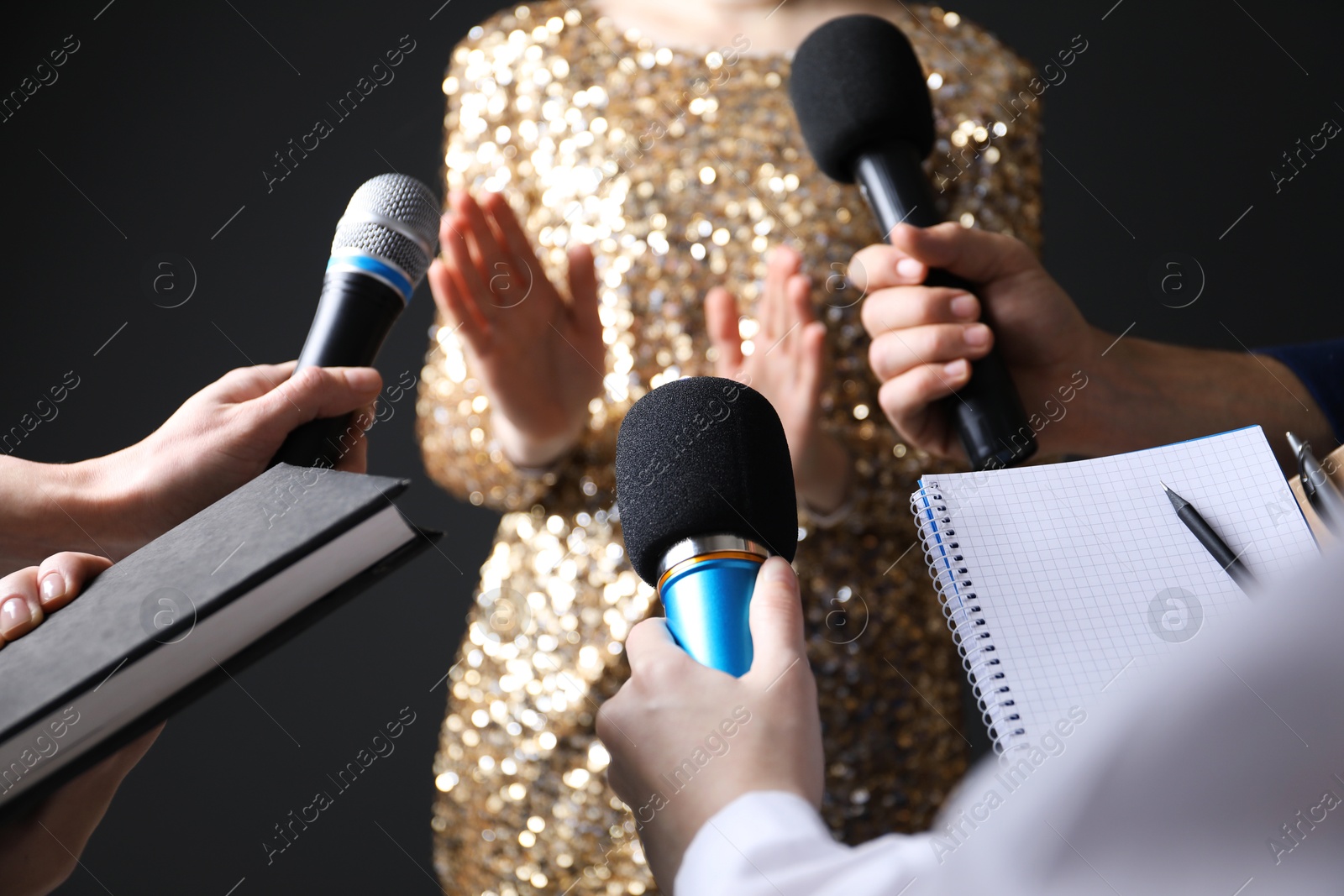 Photo of Group of journalists interviewing celebrity on black background, closeup