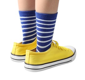 Photo of Child wearing oversized yellow sneakers on white background, closeup