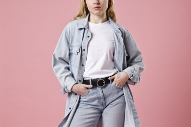 Photo of Woman in stylish jeans on pink background, closeup