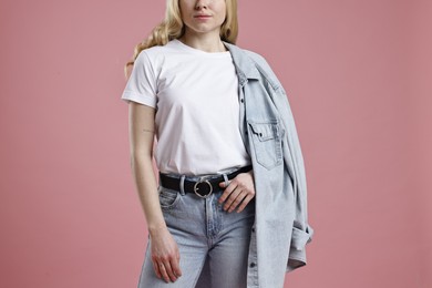 Photo of Woman in stylish jeans on pink background, closeup