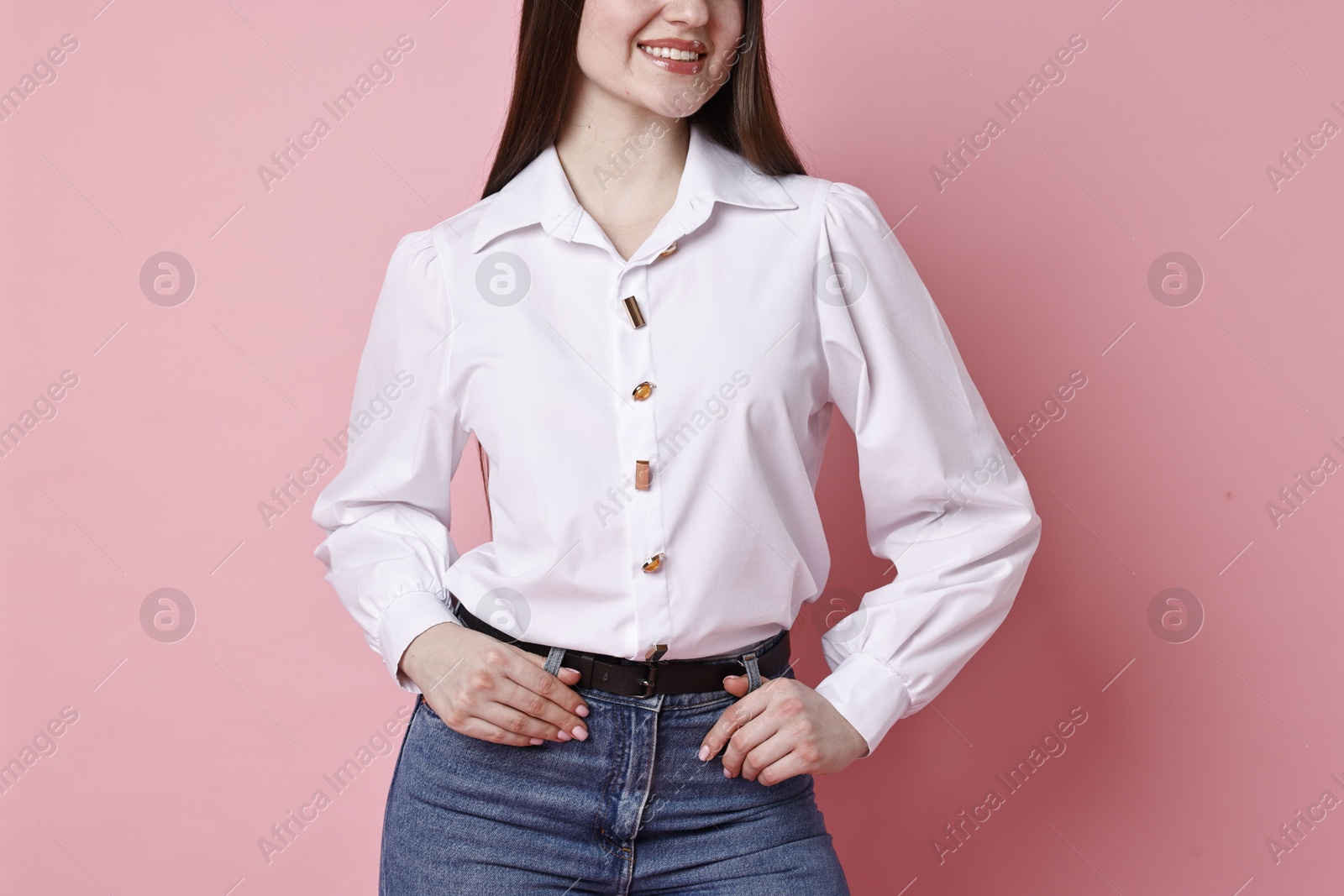 Photo of Smiling woman in stylish jeans on pink background, closeup