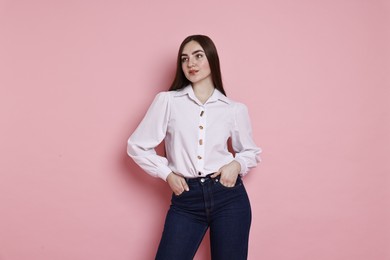 Photo of Beautiful young woman in stylish jeans on pink background