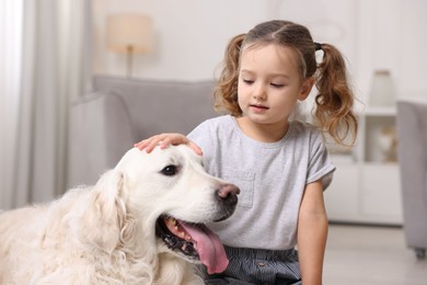 Photo of Little girl with cute dog at home