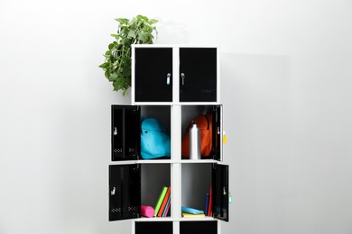 Lockers with school supplies on light background