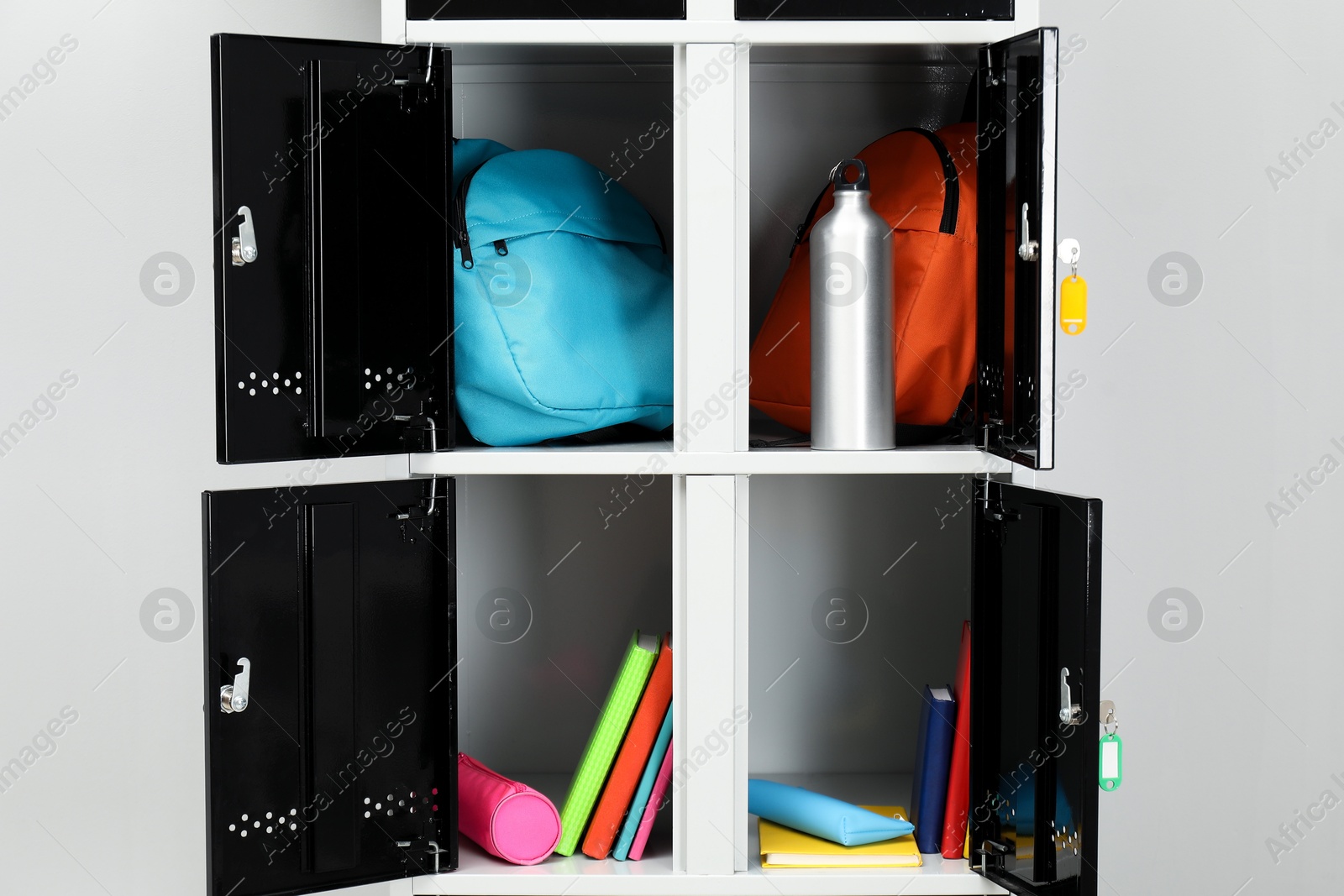 Photo of Lockers with school supplies on light background