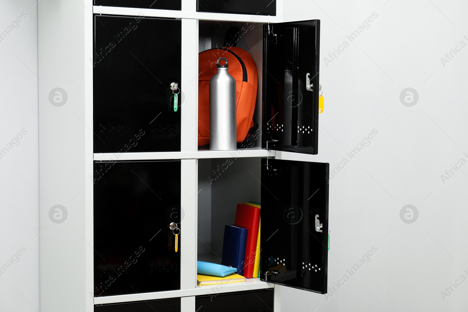 Photo of Lockers with school supplies on light background