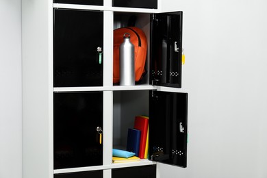 Photo of Lockers with school supplies on light background