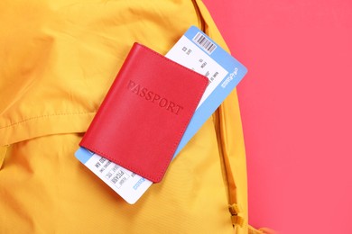 Photo of Backpack and passport with ticket on red background, closeup. Travel abroad