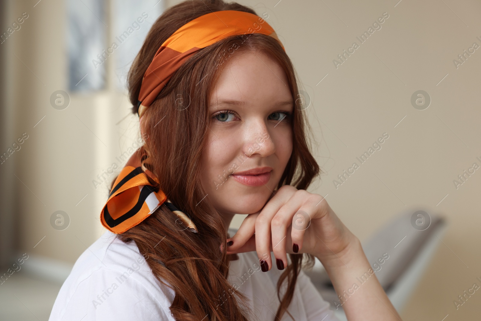 Photo of Red-haired teenage girl with stylish bandana indoors