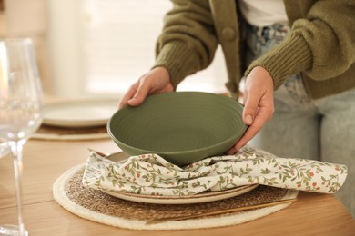 Photo of Woman setting table for dinner at home, closeup