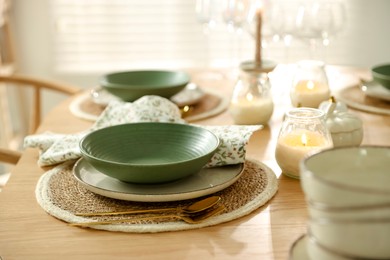 Photo of Stylish table setting with dishware, cutlery and burning candles indoors