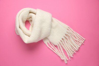 Photo of Warm woolen scarf on pink background, top view