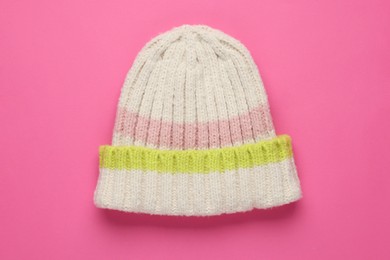 Photo of Warm woolen hat on pink background, top view