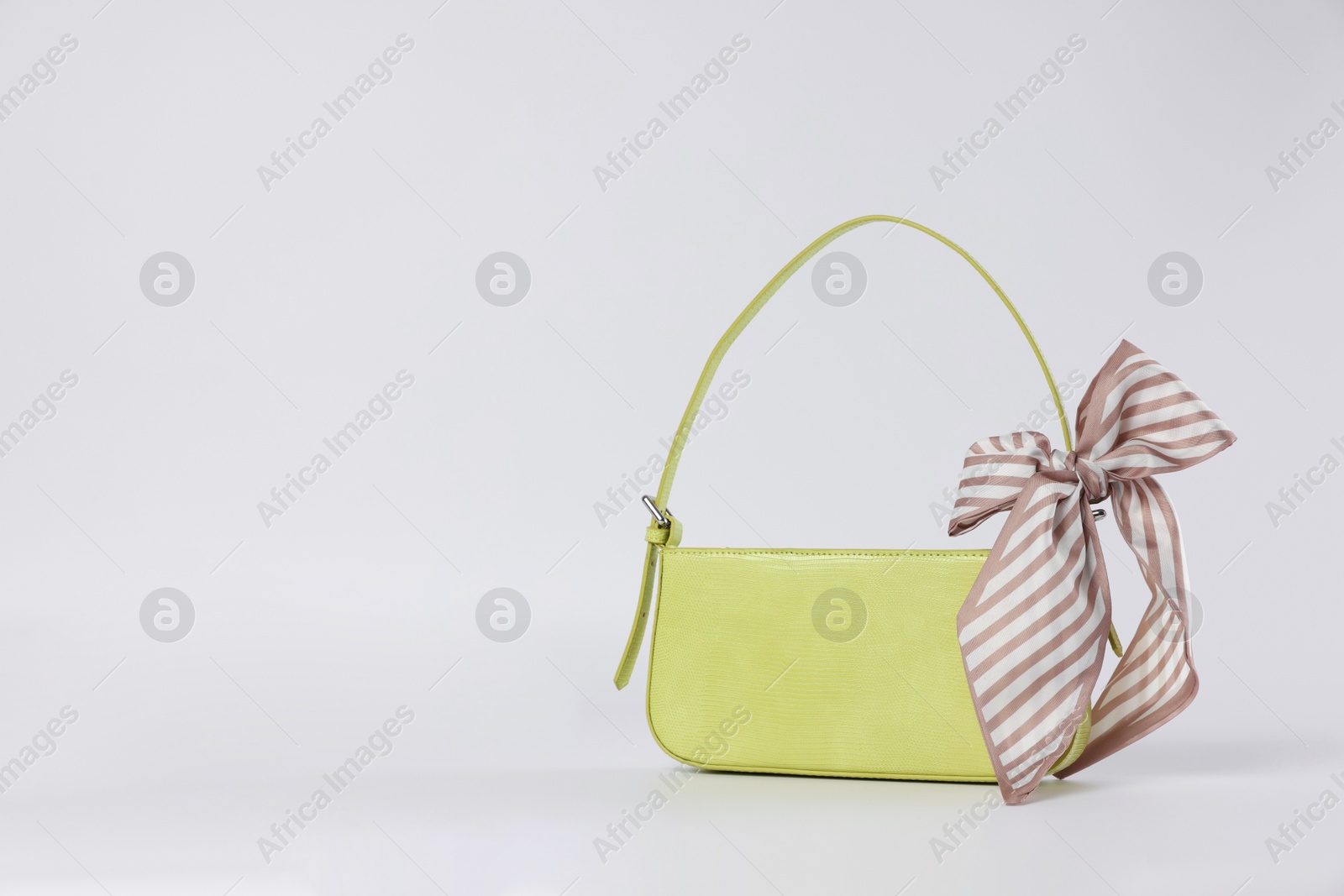 Photo of Elegant women baguette handbag with bow on white background. Space for text