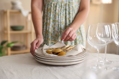 Photo of Woman setting table for dinner at home, closeup