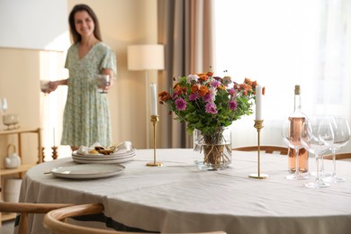 Photo of Woman setting table for dinner at home, selective focus