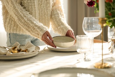 Photo of Woman setting table for dinner at home, closeup