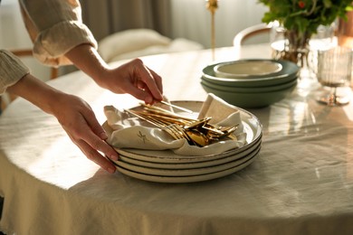 Photo of Woman setting table for dinner at home, closeup