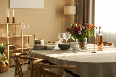 Photo of Stylish table setting with dishware, glasses and beautiful flowers indoors