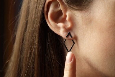 Photo of Woman wearing beautiful silver earring, closeup view