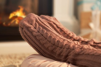 Photo of Woman in knitted socks resting at home, closeup