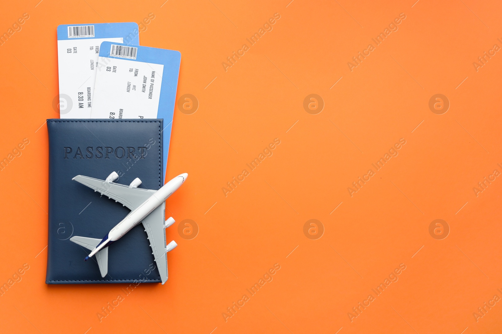 Photo of Travel agency. Flight tickets, passport and plane model on orange background, top view. Space for text