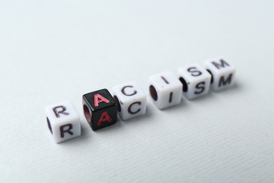 Photo of Word Racism made with beads on light grey background, closeup