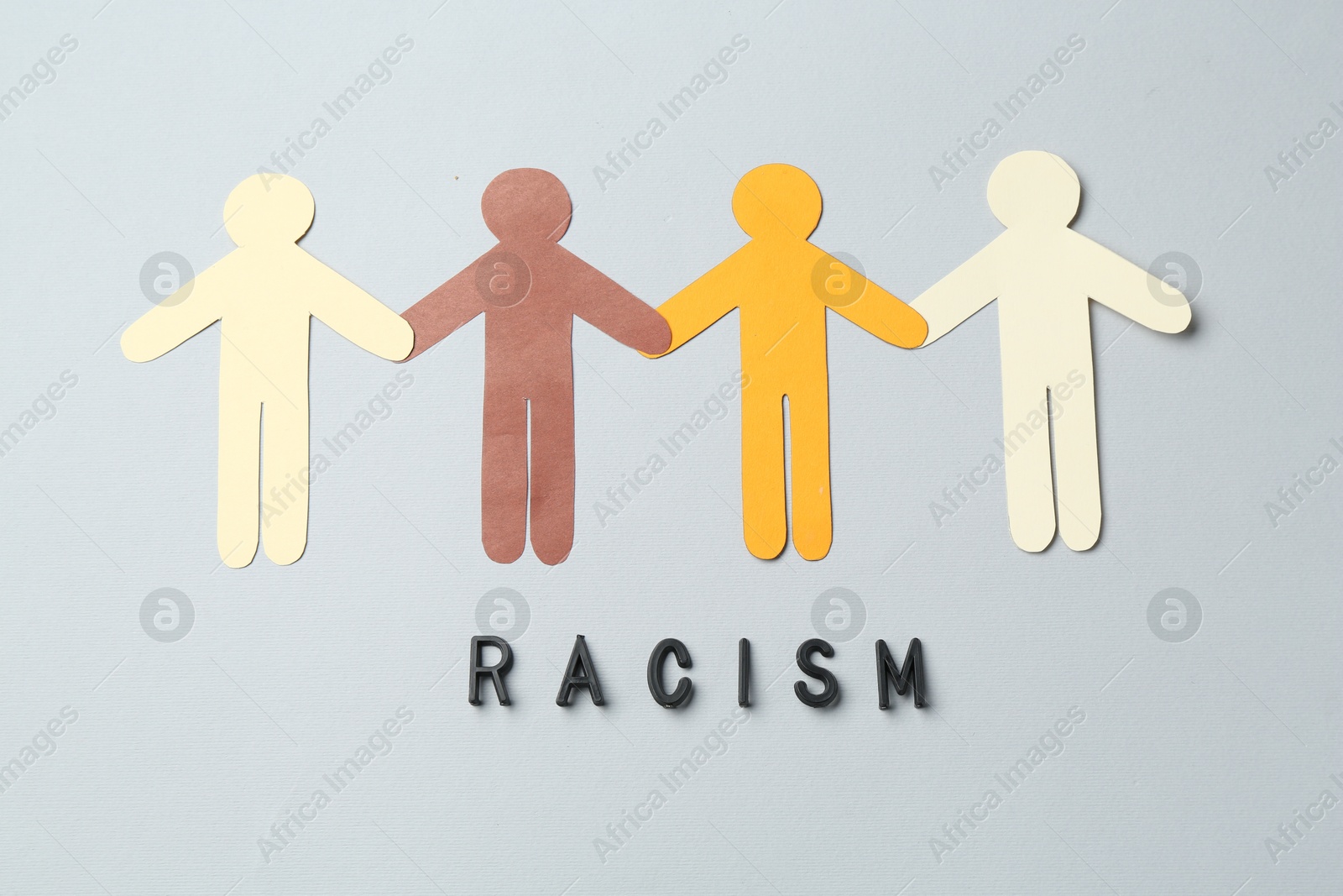 Photo of Word Racism and human paper figures of different colors on light grey background, top view