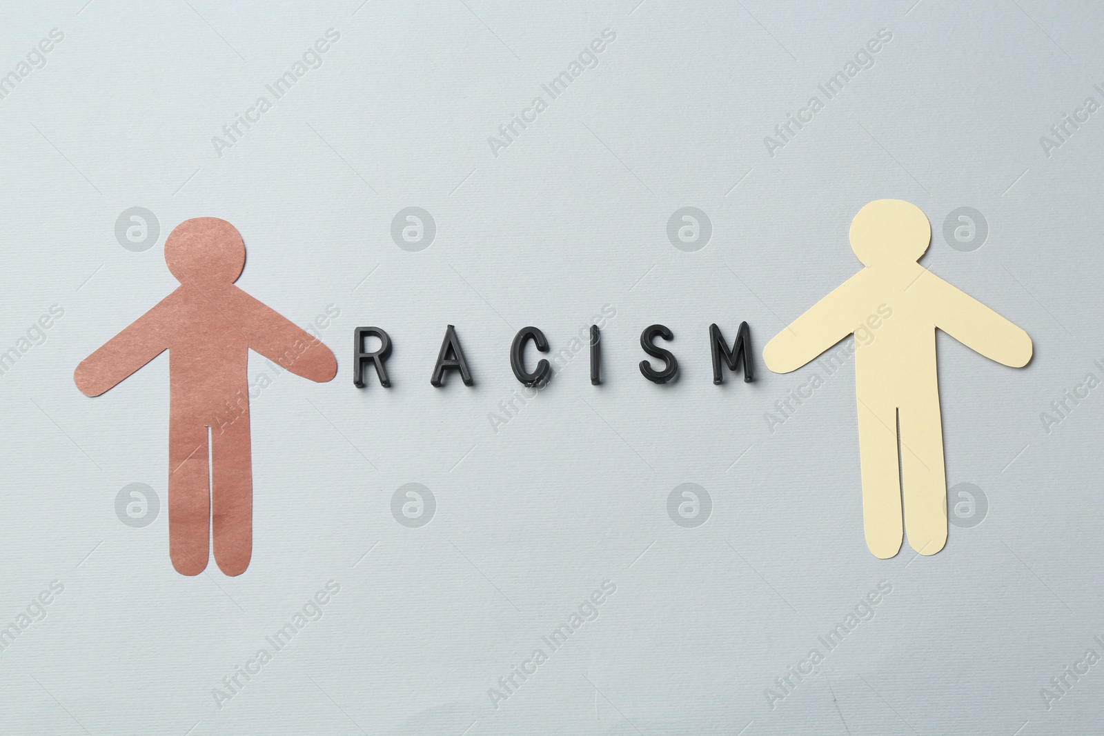 Photo of Word Racism and human paper figures of different colors on light grey background, top view