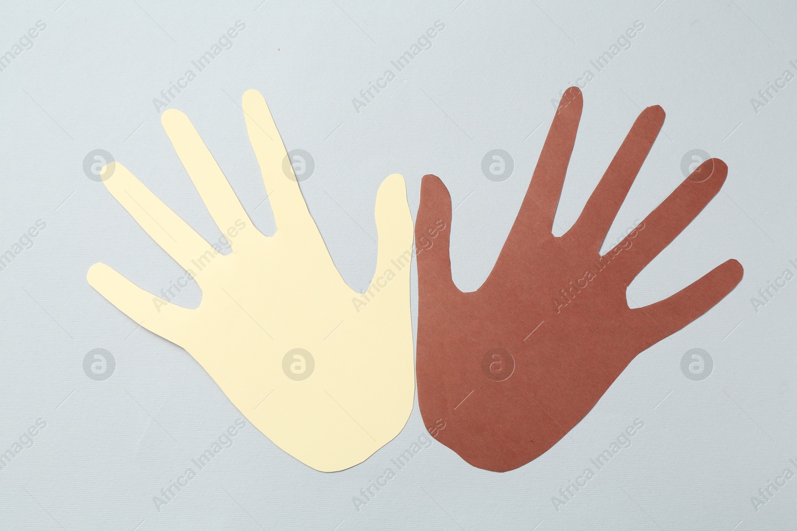 Photo of Stop racism. Hands paper figures of different colors on light grey background, top view