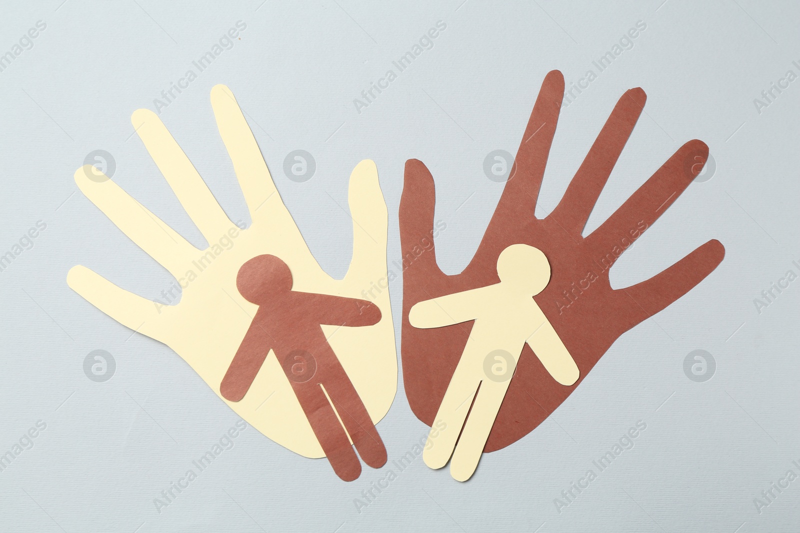 Photo of Stop racism. Hands and human paper figures of different colors on light grey background, top view