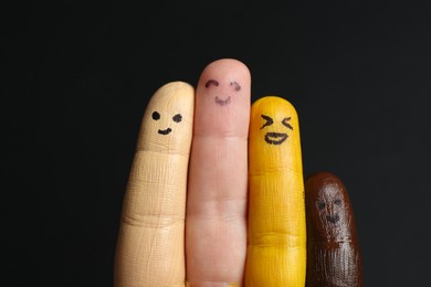 Stop racism. Woman with her fingers painted in different colors and happy faces on black background, top view